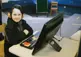 Child with headphones on sitting at a desktop computer.