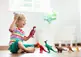 Child playing with toy dinosaurs