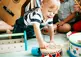 child reaching for a drum