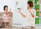 Child and adult woman dancing in a living room