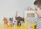 child playing with toy animals.
