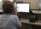 Person on the phone in front of a computer.