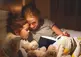 A mother reading a book to her child in bed